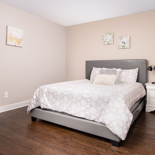 Spacious and well lit bedroom with plush carpet and large windows