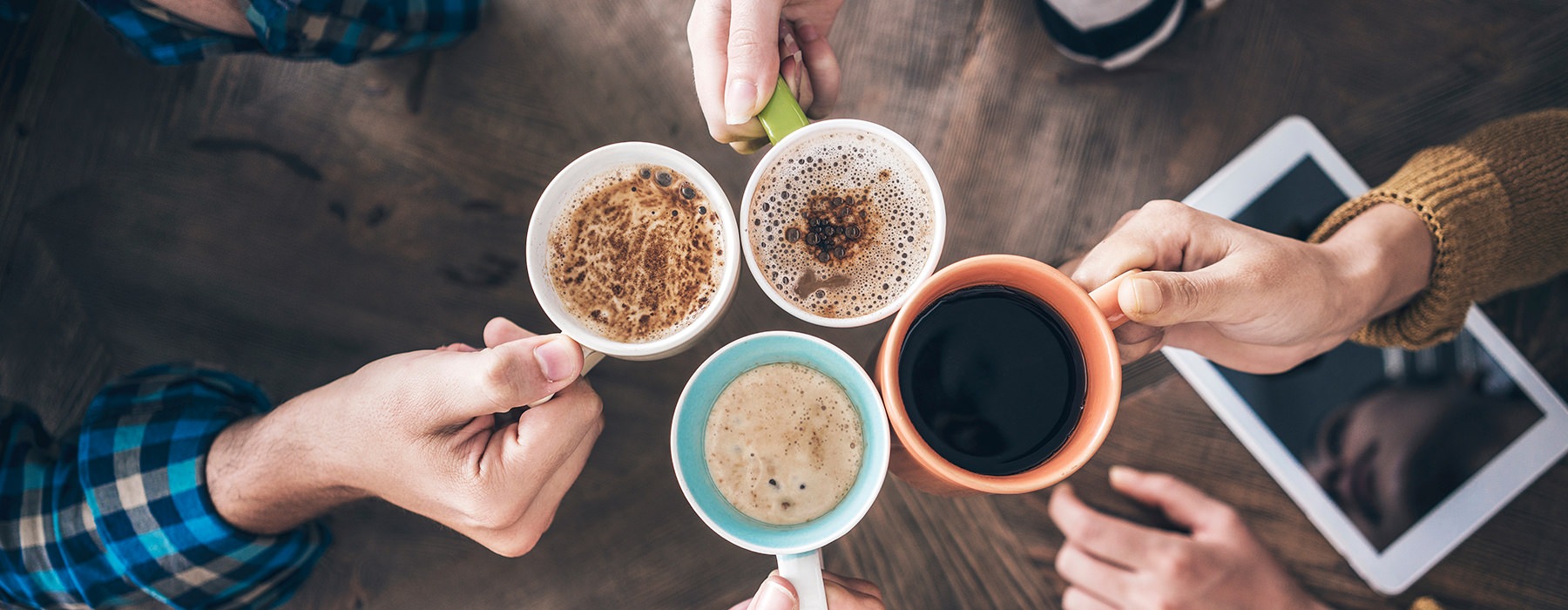 Group of people holding coffee in a circle